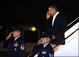 President Barack Obama salutes as he gets off Air Force One upon his arrival at Joint Base Pearl Harbor-Hickam in Honolulu, Hawaii, early today.