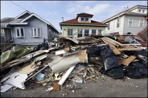 The contents of residents' once-flooded homes still lie in the streets of a neighborhood in the Rockaways section of New York on Christmas Day, nearly two months after Superstorm Sandy.