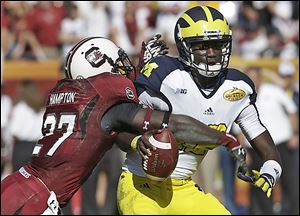 Michigan quarterback Devin Gardner (12) is sacked by South Carolina cornerback Victor Hampton (27) during the second quarter of the Outback Bowl on Tuesday.