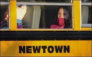 A girl sits on a Newtown bus leaving the new Sandy Hook Elementary School after the first day of classes today in Monroe, Conn.