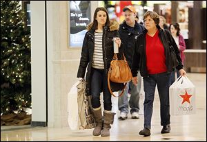 Jen Hutson, left, and her mother, Nancy Hutson, search for deals at Westfield Franklin Park mall. Promotions in the waning days before Christmas helped boost the entire holiday shopping season.