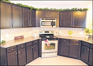 The kitchen’s many cabinets provide ample storage. A long snack bar offers additional counter space. The sunroom’s sliding doors lead to a covered porch.
