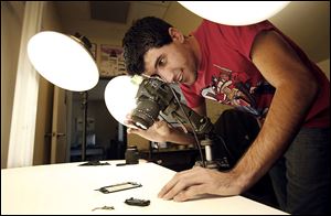 Andrew Goldberg, technical writer at iFixit, photographs a teardown of a iphone at their San Luis Obispo, California office where the company illustrates how to repair your electronics yourself through online photographs and videos. 
