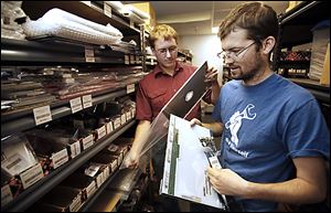 Co-founders of iFixit Kyle Wiens CEO, left,  and Luke Soules CXO, right, look at the replacement parts of electronic devices.