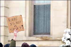 Protesters hold aloft a sign protesting the alleged rape of a 16-year-old girl from West Virginia.