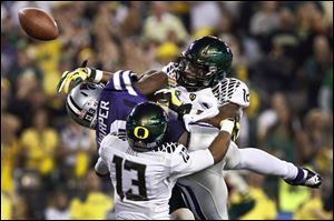 Oregon's Brian Jackson (12) and Troy Hill (13) break up a pass intended for Kansas State's Chris Harper.