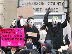 Activists from the online group Anonymous, outraged by the prospect of athletes possibly being given preferential treatment, protest at the Jefferson County Courthouse in Steubenville.