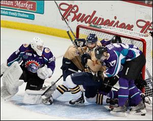 Orlando Solar Bears' goalie John Curry, left, looks back as a mixture of Walleye and Solar Bears are in the net.