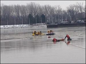 Washington Township firefighters and members of the Coast Guard work to rescue a woman from the ice on the Maumee River.