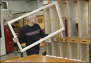 Kevin Wiley of Perrysburg stores a frame after assembling it at American Frame in Maumee.