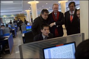 Executive Chairman of Google, Eric Schmidt, third from left, and former New Mexico governor Bill Richardson, second from right, watch as a North Korean student surfs the Internet at a computer lab during a tour of Kim Il Sung University in Pyongyang, North Korea.