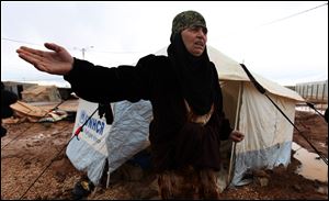 A Syrian refugee woman complains about limited winter resources, at Zaatari Syrian refugee camp, near the Syrian border in Mafraq, Jordan, Tuesday, Jan. 8, 2013. Syrian refugees in a Jordanian camp attacked aid workers with sticks and stones on Tuesday, frustrated after cold, howling winds swept away their tents and torrential rains flooded muddy streets overnight. Police said seven aid workers were injured. (AP Photo/Mohammad Hannon)
