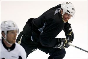 Pittsburgh Penguins captain Sidney Crosby (87) begins a rush up ice behind James Neal during an informal workout with a dozen of the NHL hockey team's players in Pittsburgh, Monday.