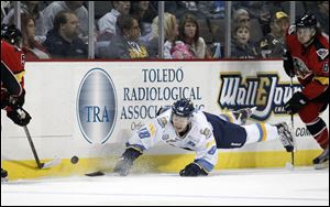 Walleye Randy Rowe, 18, dives after the puck. Rowe says he’s still positive about Toledo’s chances to be in the playoffs.