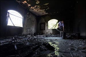A Libyan man investigates the inside of the U.S. Consulate after an attack that killed four Americans, including Ambassador Chris Stevens, on the night of Tuesday, Sept. 11, 2012, in Benghazi, Libya.