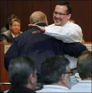 Shaun Enright is embraced by  George Tucker, exec. secretary-treasurer of the Toledo area AFL-CIO Council, after being appointed as the new member of Toledo City Council during a vote at Council Chambers at Government Center.