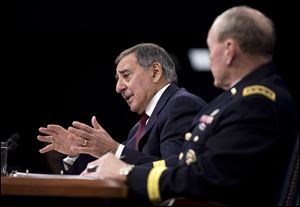Defense Secretary Leon Panetta, accompanied by Joint Chiefs Chairman Gen. Martin Dempsey, gestures during a news conference today at the Pentagon.