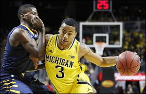 Michigan sophomore Trey Burke drives against West Virginia's Eron Harris. Burke, a Columbus native who won Mr. Basketball in Ohio, leads the Wolverines with an 18.2 scoring average.