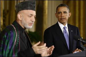 President Barack Obama listens as Afghan President Hamid Karzai speaks during their joint news conference in the East Room at the White House in Washington.