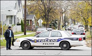 Toledo police block a street following a report of two people shot, an occurrence that mirrors Detroit.