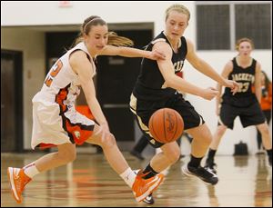 Southview's sophomore Maria Pappas (12) retains control of the ball after an attemptedd steal by Perrysburg's senior guard Maddie Williams (12) during the quarter of Friday night's game at Southview. The Yellow Jackets beat the Cougars 53-39.