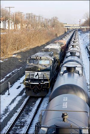 A Norfolk Southern train hauls empty oil tank cars in Toledo. Experts say rail travel is riskier than pipelines, but is faster to start up.