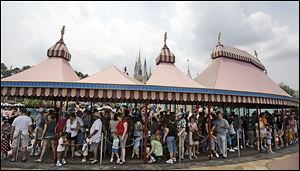 Guests wait in long lines at the Dumbo ride at the Magic Kingdom theme park at Walt Disney World. The MyMagic+ and an app called My Disney experience can make those long waits in line go faster. Guests can  preselect fantasy apps for rides or other seating.