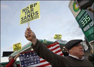 Terry Lodge, of Holldand, holds a sign during the protest.
