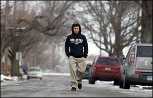 Ramon Allen, 15, walks down Prouty Avenue on his way home from school. He blames the violence on 'gang wars' and fights that start in public and end in neighborhood shootings.