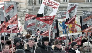People carry posters of Russian President Vladimir Putin  during a protest in Moscow against Parliament’s ban on U.S. adoptions. Many ques­tioned the moral prin­ci­ples of a ban in a nation with so many chil­dren in fos­ter care or or­phan­ages.