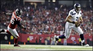 Seattle Seahawks quarterback Russell Wilson (3) runs the ball into the end zone as Atlanta Falcons outside linebacker Sean Weatherspoon (56) looks on during the second half of an NFC divisional playoff NFL football game in Atlanta. 