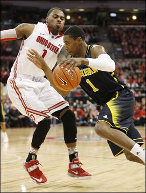 Ohio State's DeShaun Thomas, left, tries to slow down Michigan's Glenn Robinson III, right, during the second half of an NCAA college basketball game toady in Columbus. Ohio State won 56-53.