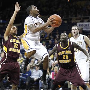University of Toledo guard Julius Brown (20) goes to the net  against  Central Michigan's Kyle Randall (12) and Olivier Mbaigoto (25) on Saturday, at Savage Arena in Toledo.
