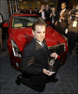 Cadillac Chief Engineer David Leone kneels in front of the Cadillac ATS which was named North American Car of the Year.