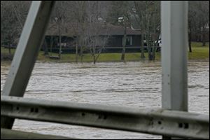 The Maumee River crested its banks and surged into low-lying surrounding areas Sunday afternoon in Waterville. The river was expected to continue to rise through Tuesday.