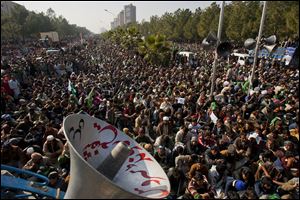 Supporters of Pakistani Sunni Muslim cleric Tahir-ul-Qadri listen to a speech by ul-Qadri, unshown, at an anti-government rally in Islamabad, Pakistan.