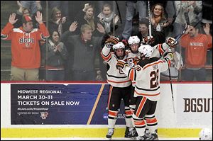 Bowling Green’s Robert Shea, right, celebrates with his teammates during the Falcons’ win against Notre Dame on Tuesday night at BGSU Ice Arena.