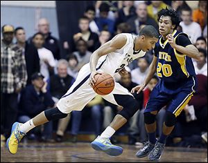 Marc Loving of St. John's drives past Whitmer's Chris Boykin. Loving has signed to play at Ohio State.