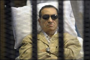 Egypt's ex-President Hosni Mubarak lays on a gurney inside a barred cage in the police academy courthouse in Cairo, Egypt, last July.