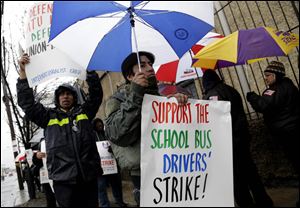 Bus drivers and supporters walk a picket line in front of a bus depot in New York.