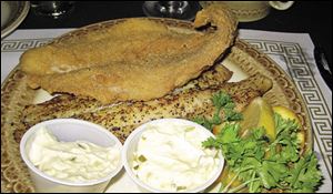 Two pieces of Lake Superior whitefish, one baked with lemon and seasoning, the other deep fried.