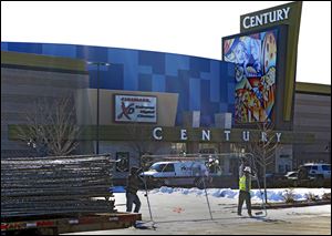 Workers with American Fence remove the fence from around the Century theater in Aurora, Colo.