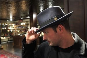 Adam Caine tries on a hat at Goorin Bros. in Uptown, Minneapolis.