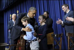 President Barack Obama, accompanied by Vice President Joe Biden hugs eight-year-old letter writer Grant Fritz during a news conference on proposals to reduce gun violence Wednesday in Washington.