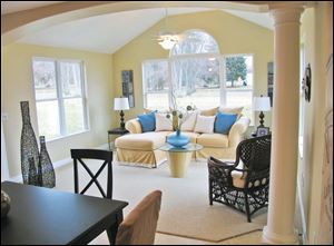 An archway supported by pillars defines the opening to this delightful sunroom.