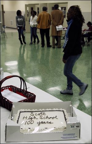 Scott High School students pass a cake celebrating the school's 100th anniversary Thursday.