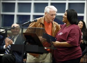 Jerry Chabler presents Scott High School principal Treva Jeffries with a proclamation from Lucas County during a program celebrating the school’s 100th anniversary.