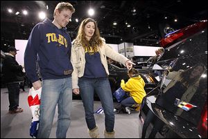 Josh Pettrey of  Ypsilanti, Mich., and Sarah Przybylski of Peters-burg, Mich., look at the back of a Cadillac CTS on the first day of the North American International Auto Show in Detroit.