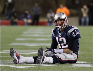 New England Patriots quarterback Tom Brady sits on the field after getting hit during the second half of theAFC championship game against the Baltimore Ravens Sunday in Foxborough, Mass. He threw two interceptions in a 28-13 loss.
