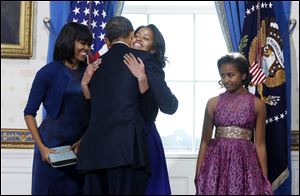 President Obama hugs daughter Malia as the First Lady and daughter Sasha look on. Sasha told her father ‘good job,’ after the oath was completed.